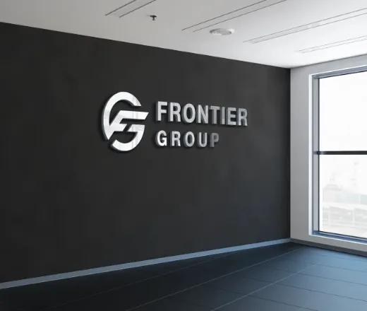 オフィスの黒い壁面に設置された、スタイリッシュなFRONTIER GROUPのシルバーロゴ。